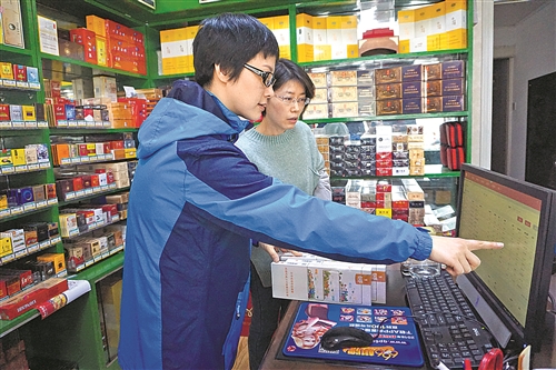 客户经理郑霞（左）在指导零售客户运用该系统盘点库存